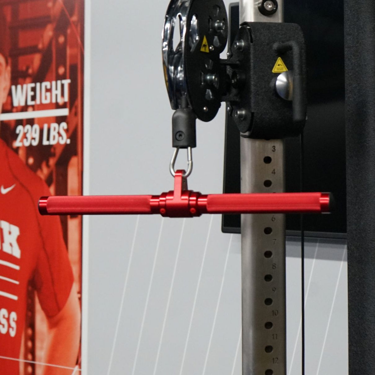 Gronk Fitness red revolving straight bar in use on a cable machine
