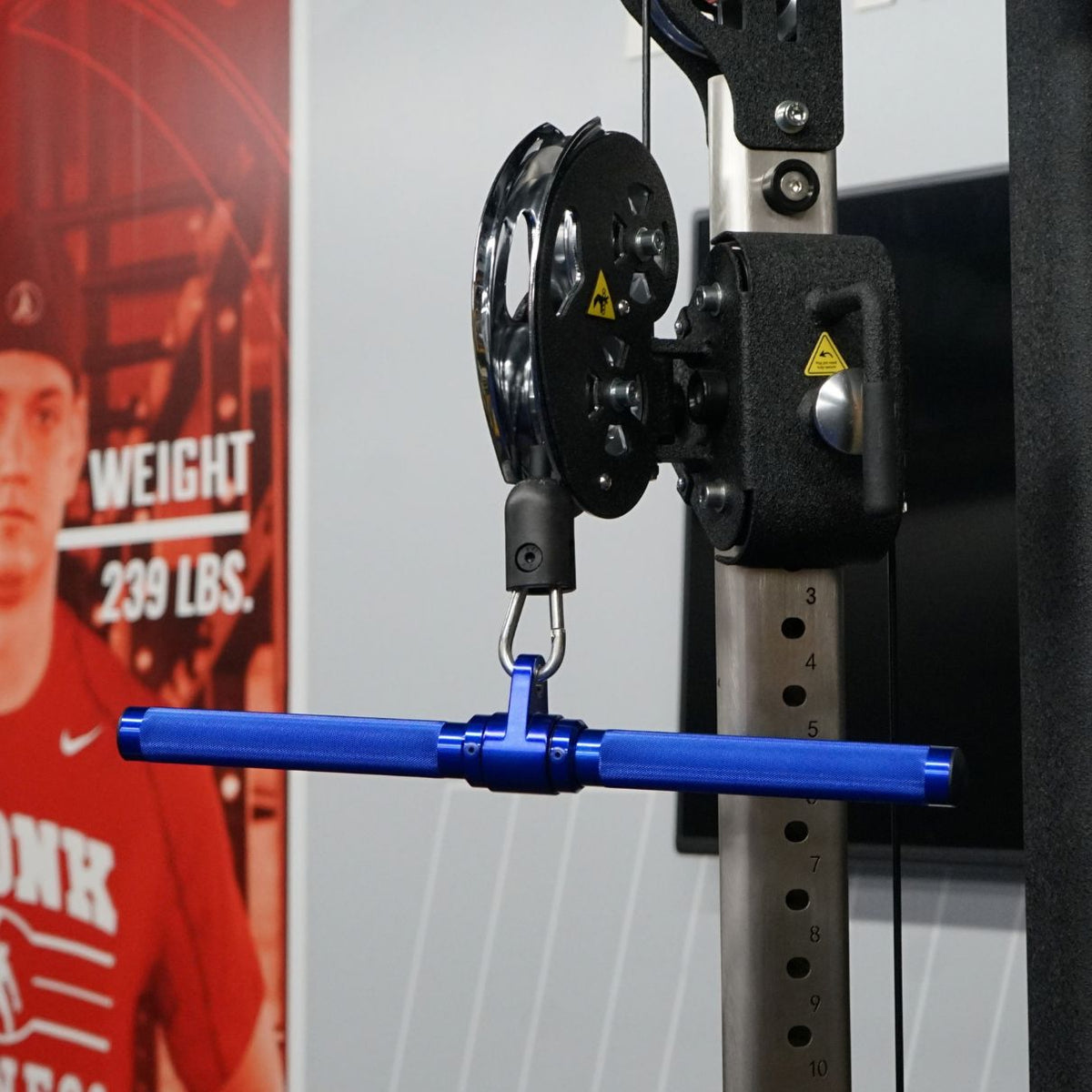 Gronk Fitness blue revolving straight bar in use on a cable machine