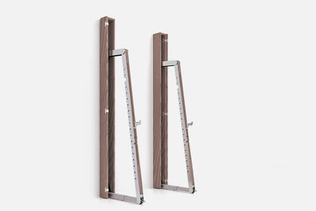 Two wall-mounted squat racks in medium-brown wood, one folded shut and one opened to a silver ladder