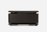 Front view of a black storage bench with the padded lid raised and resistance bands visible inside